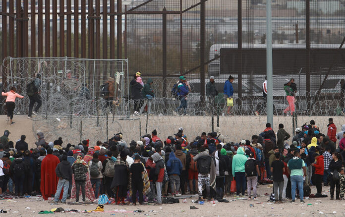 Migrantes intentan derrumbar valla